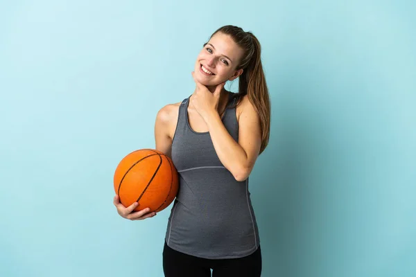 Młoda Kobieta Gra Koszykówkę Odizolowany Niebieskim Tle Szczęśliwy Uśmiechnięty — Zdjęcie stockowe