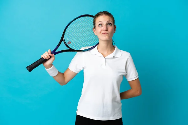 若い女性テニス選手は青の背景に隔離され 上を見上げます — ストック写真