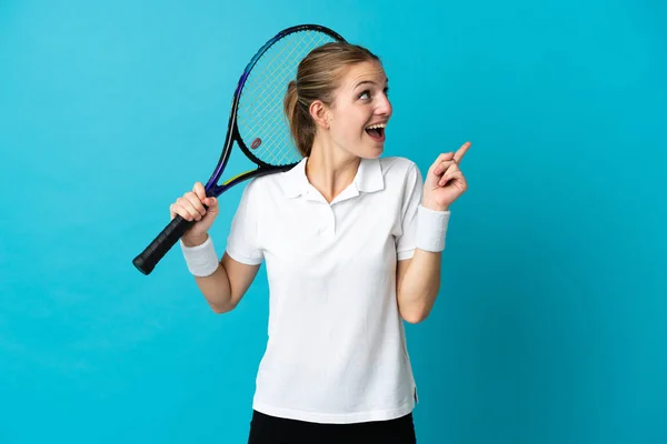 指を持ち上げながら解決策を実現しようと青色の背景に隔離された若い女性テニス選手 — ストック写真