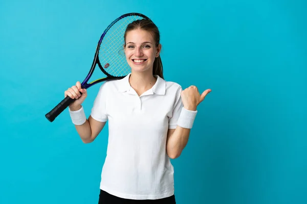 Joven Jugadora Tenis Aislada Sobre Fondo Azul Apuntando Hacia Lado — Foto de Stock