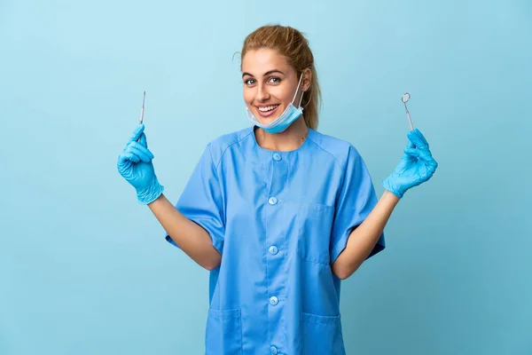 Mladá Žena Zubař Drží Nástroje Přes Izolované Modré Pozadí — Stock fotografie
