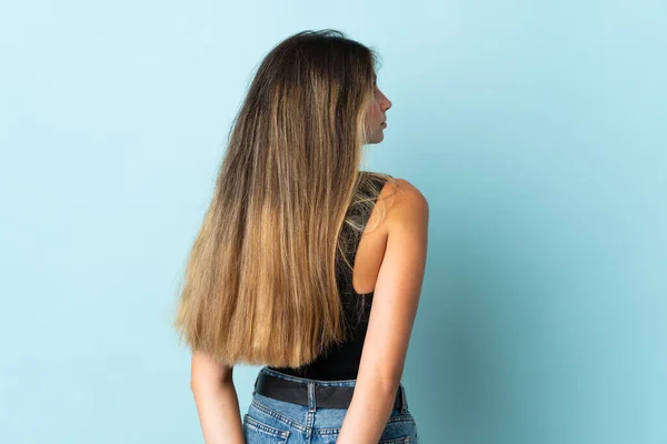 Jonge Blanke Vrouw Geïsoleerd Blauwe Achtergrond Achterste Positie Terugkijkend — Stockfoto