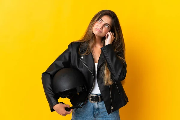 女性保持Aオートバイヘルメット絶縁で黄色の背景不満とカバー耳 — ストック写真