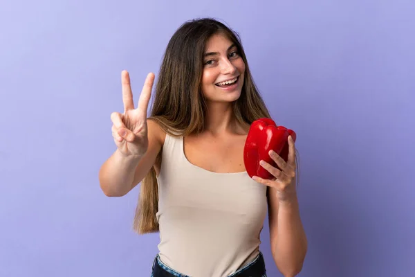 Jovem Segurando Uma Pimenta Isolada Fundo Roxo Sorrindo Mostrando Sinal — Fotografia de Stock