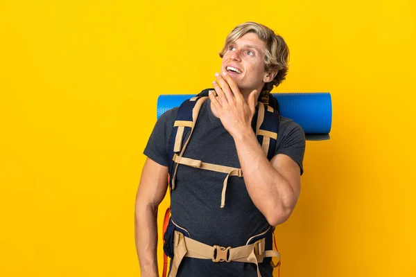 Young Mountaineer Man Isolated Yellow Background Looking While Smiling — Stockfoto