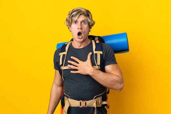 Young Mountaineer Man Isolated Yellow Background Surprised Shocked While Looking — стоковое фото