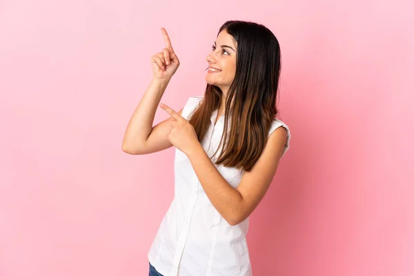 Pembe Arka Planda Izole Edilmiş Genç Beyaz Kadın Işaret Parmağıyla — Stok fotoğraf