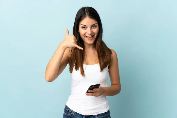 Молода Біла Жінка Використовує Мобільний Телефон Ізольовано Синьому Фоні Роблячи — стокове фото