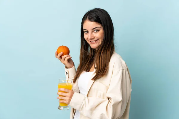 Ung Kaukasisk Kvinna Isolerad Blå Bakgrund Håller Apelsin Och Apelsinjuice — Stockfoto