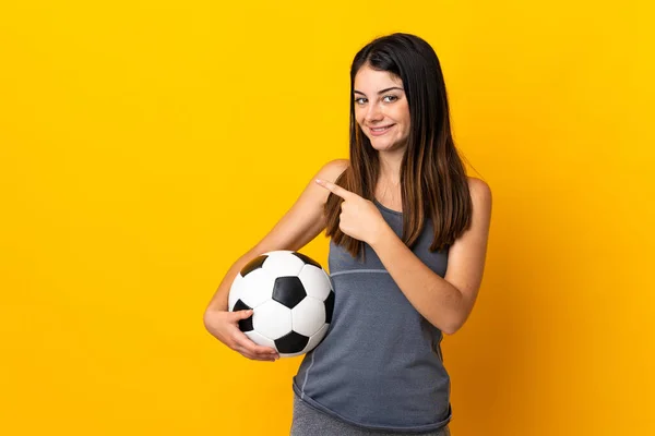 Młoda Piłkarz Kobieta Izolowane Żółtym Tle Wskazując Stronie Przedstawić Produkt — Zdjęcie stockowe
