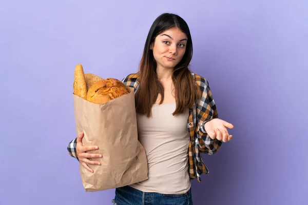 Молодая Женщина Держит Сумку Полную Хлеба Изолированы Фиолетовом Фоне Делает — стоковое фото