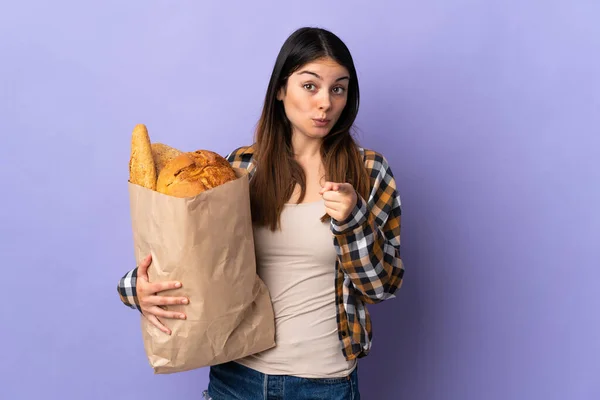 Young Woman Holding Bag Full Breads Isolated Purple Background Surprised — Stock Fotó