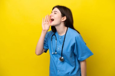 Young surgeon doctor Russian woman isolated on yellow background shouting with mouth wide open to the side