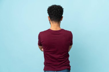 Faslı genç adam arka planda mavi arka planda izole edildi.