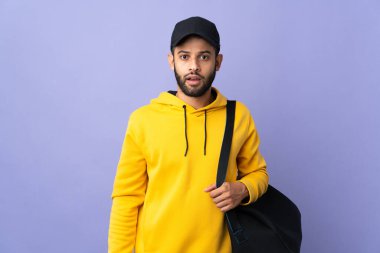 Young sport Moroccan man with sport bag isolated on purple background with surprise facial expression