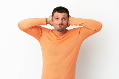 Brezilyalı adam izole edilmiş beyaz arka planda hayal kırıklığına uğramış ve kulaklarını kapatmış.