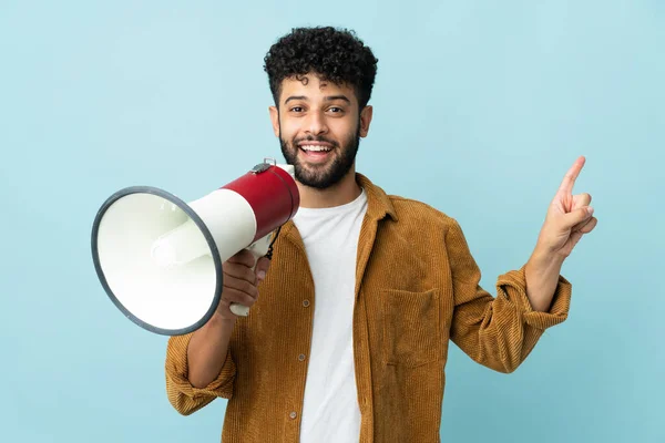 Jovem Marroquino Isolado Fundo Azul Gritando Através Megafone Apontando Lado — Fotografia de Stock