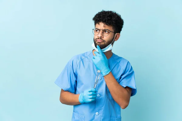 Moroccan Dentist Man Holding Tools Isolated Blue Background Having Doubts — Fotografia de Stock
