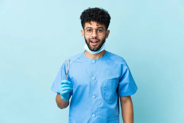 Moroccan Dentist Man Holding Tools Isolated Blue Background Surprise Facial — стоковое фото