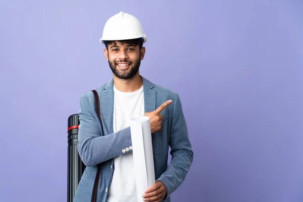 Young Architect Moroccan Man Helmet Holding Blueprints Isolated Background Pointing — Φωτογραφία Αρχείου