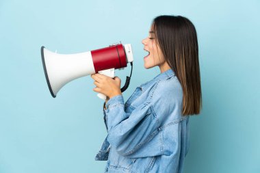 Sarı arka planda izole edilmiş genç bir kız megafondan bir şey duyurmak için bağırıyor.