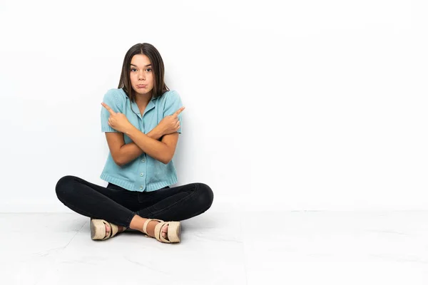 Chica Adolescente Sentada Suelo Señalando Los Laterales Que Tienen Dudas — Foto de Stock