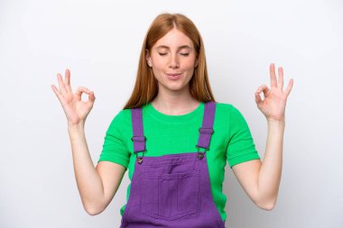 Zen pozisyonunda beyaz arka planda izole genç kızıl saçlı kadın.