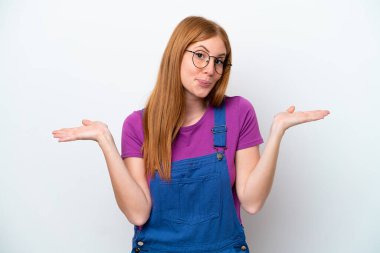 Genç kızıl saçlı kadın, beyaz arka planda izole edilmiş ve ellerini kaldırırken şüpheye düşmüş.