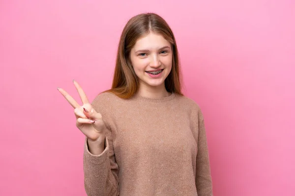 Έφηβη Ρωσίδα Απομονωμένη Ροζ Φόντο Χαμογελώντας Και Δείχνοντας Σύμβολο Της — Φωτογραφία Αρχείου