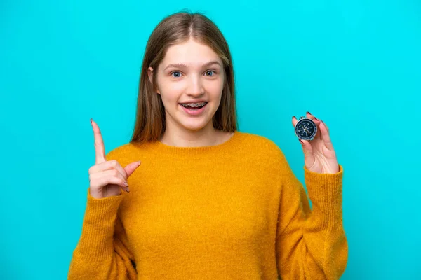 年轻的俄罗斯女孩拿着指南针 蓝色背景 指向一个伟大的想法 — 图库照片