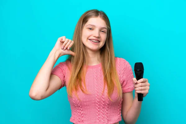 Cantante Chica Rusa Recogiendo Micrófono Aislado Sobre Fondo Azul Orgulloso — Foto de Stock