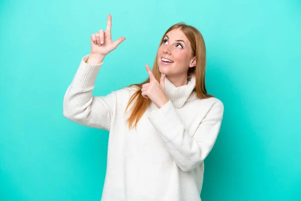 Ung Rödhårig Kvinna Isolerad Blå Bakgrund Pekar Med Pekfingret Bra — Stockfoto