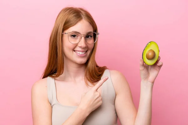 Junge Rothaarige Frau Mit Einer Avocado Auf Rosa Hintergrund Die — Stockfoto