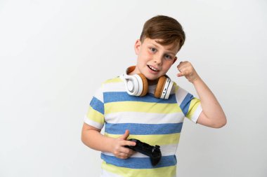 Beyaz arka planda izole edilmiş oyun bloknotu tutan küçük kızıl saçlı çocuk telefon hareketi yapıyor. Bana geri dönüş işareti ver.