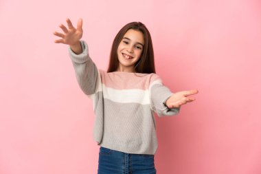 Pembe arka planda izole edilmiş küçük bir kız sunar ve davet eder.