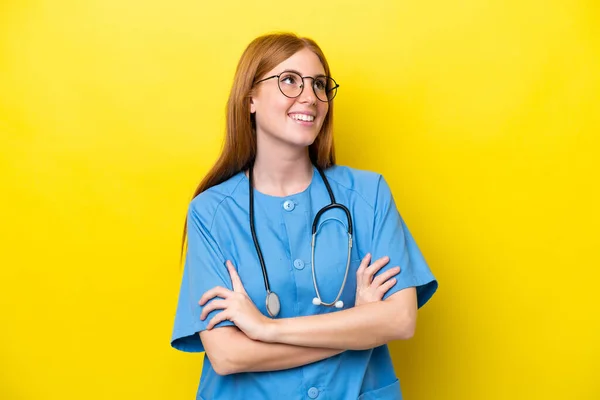 Junge Rothaarige Krankenschwester Frau Isoliert Auf Gelbem Hintergrund Schaut Auf — Stockfoto