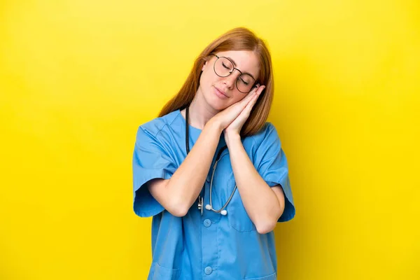 Νεαρή Κοκκινομάλλα Νοσοκόμα Γυναίκα Απομονωμένη Κίτρινο Φόντο Κάνοντας Χειρονομία Ύπνου — Φωτογραφία Αρχείου