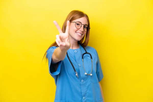 Junge Rothaarige Krankenschwester Isoliert Auf Gelbem Hintergrund Lächelnd Und Mit — Stockfoto