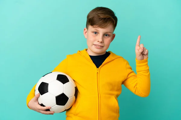 Roodharige Kind Spelen Voetbal Geïsoleerd Blauwe Achtergrond Tonen Heffen Van — Stockfoto