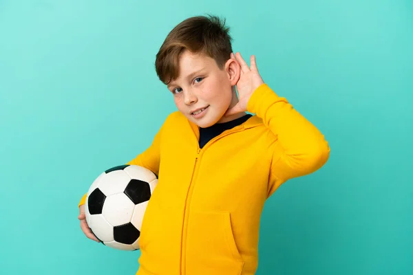 Roodharige Kind Spelen Voetbal Geïsoleerd Blauwe Achtergrond Luisteren Naar Iets — Stockfoto