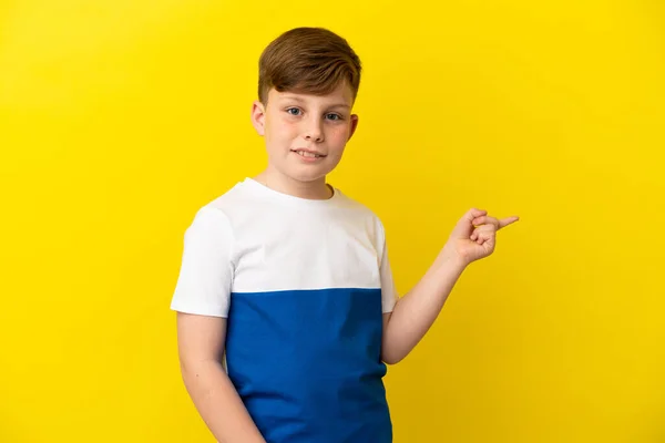 Μικρό Κοκκινομάλλικο Αγόρι Απομονωμένο Κίτρινο Φόντο Που Δείχνει Δάχτυλο Στο — Φωτογραφία Αρχείου