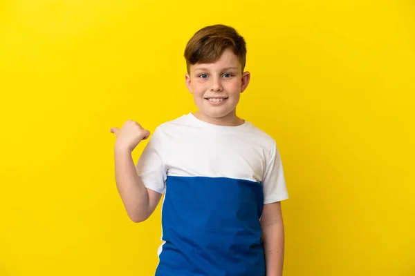Malý Ryšavý Chlapec Izolované Žlutém Pozadí Ukazuje Stranu Prezentovat Produkt — Stock fotografie