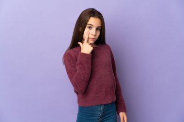 Mor arka planda izole edilmiş küçük kız bir şey gösteriyor.