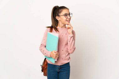 Küçük kız izole edilmiş arka planda yan tarafa bakıyor ve gülümsüyor.