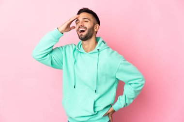 Pembe arka planda izole edilmiş genç beyaz adam çok gülümsüyor.