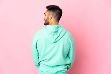 Kafkasyalı genç adam pembe arka planda izole edilmiş.