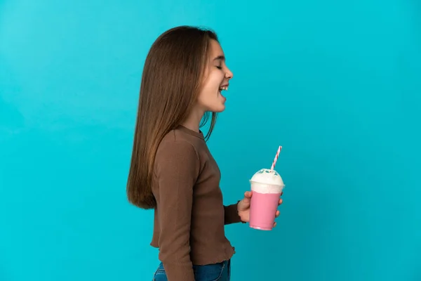 Liten Flicka Med Jordgubbsmjölkshake Isolerad Blå Bakgrund Skrattar Sidoläge — Stockfoto