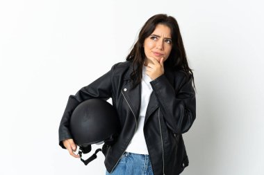 Beyaz arka planda motosiklet kaskı tutan kadının şüpheleri var.