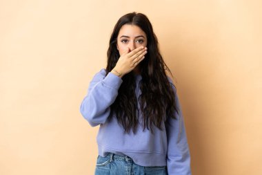 İzole edilmiş arka planda, ağzı elle kapatan beyaz bir kadın.