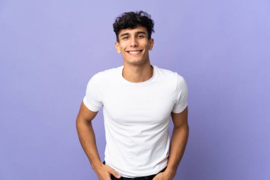 Arjantinli genç adam arka planda yalnız gülüyor.